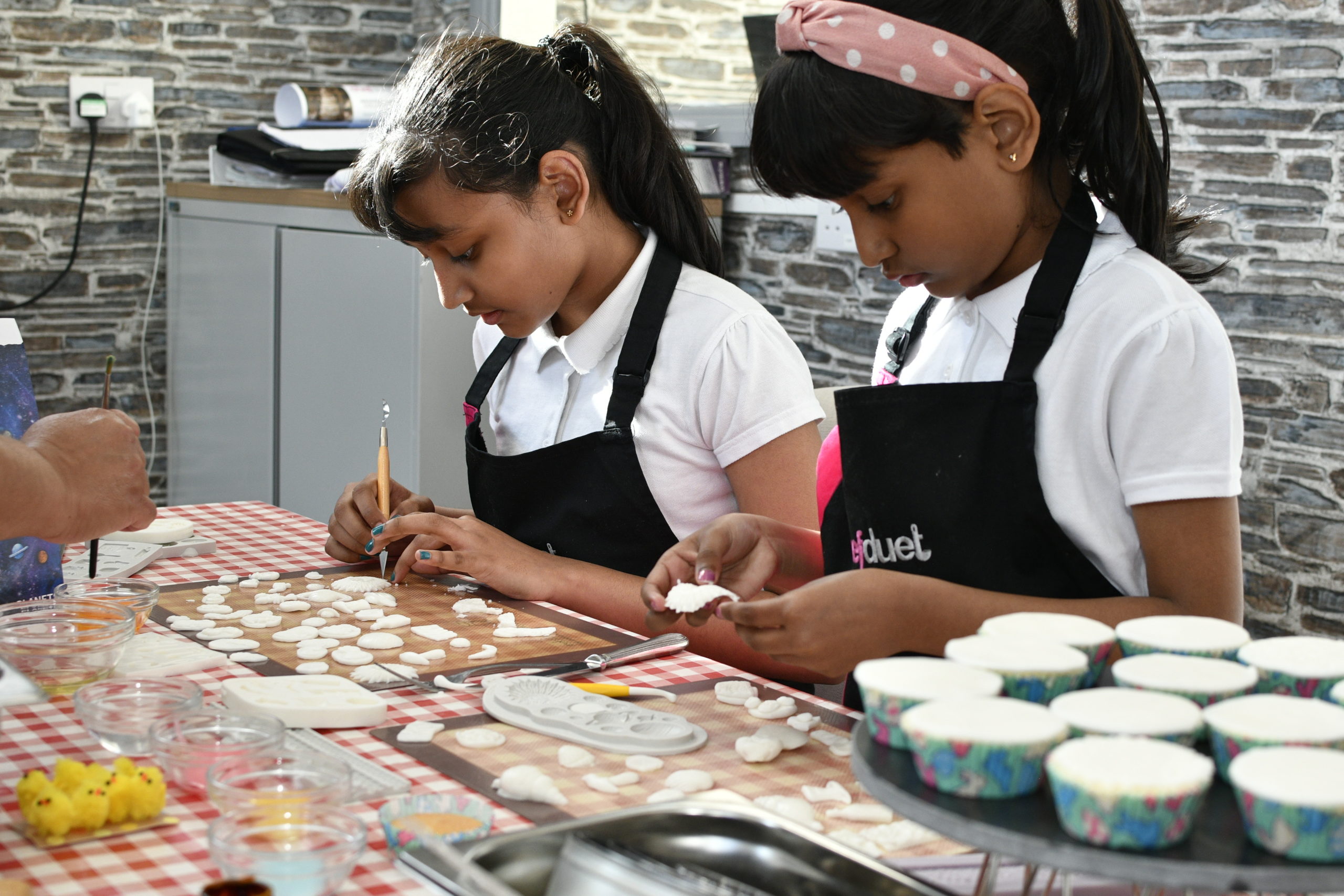 Children painting the icing on cupcakes
